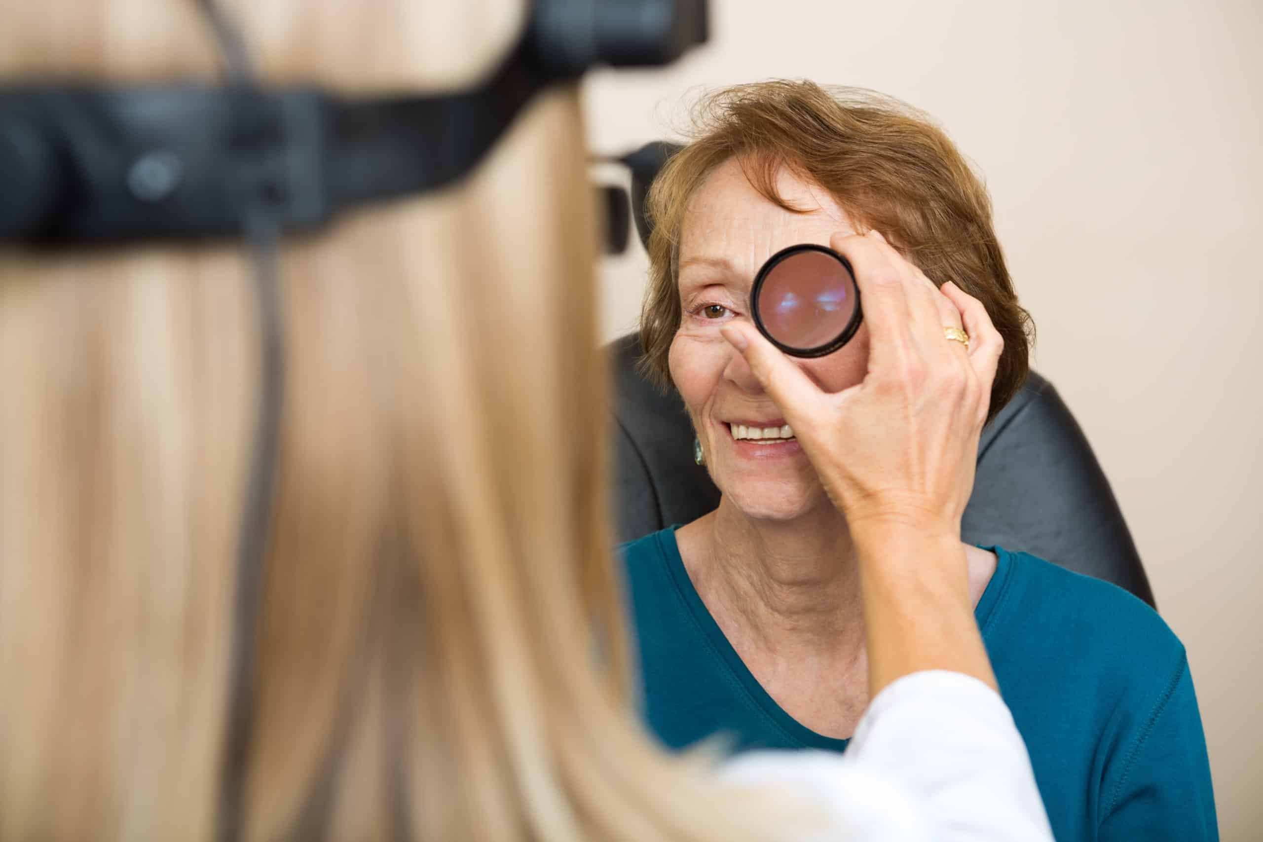 Female,Optician,Examining,Senior,Woman's,Eye,With,Binocular,Indirect,Ophthalmoscope